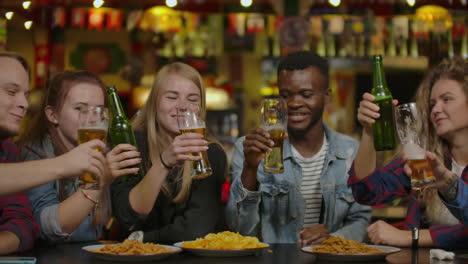 Diverse-Group-of-Friends-Celebrate-with-a-Toast-and-Clink-Raised-Glasses-with-Various-Drinks-in-Celebration.-Beautiful-Young-People-Have-Fun-in-the-Stylish-Bar/-Restaurant.